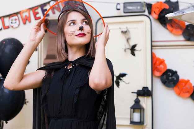 Medium shot woman holding witch hat