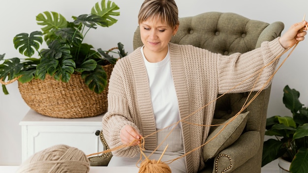 Medium shot woman holding yarn