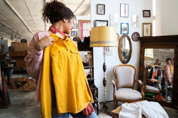 Medium shot woman holding yellow shirt