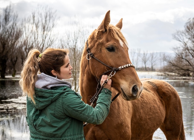 Medium shot woman and horse outdoors