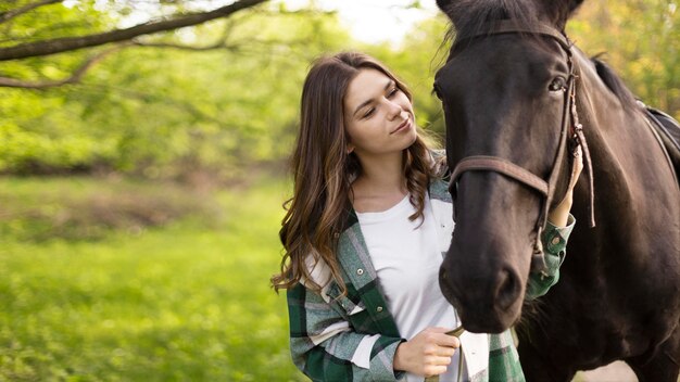 medium shot woman and horse outdoors