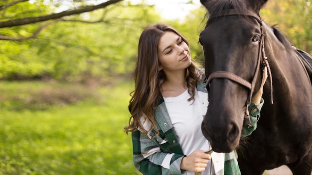 ミディアムショットの女性と屋外の馬