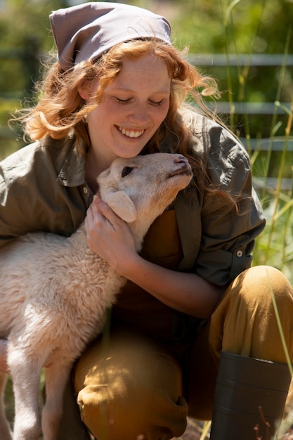 Medium shot woman hugging lamb