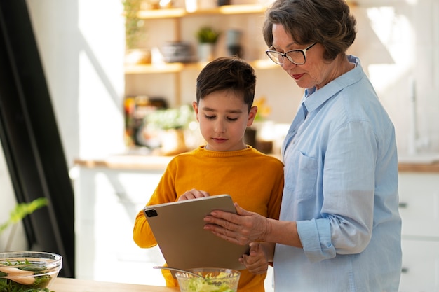 Free photo medium shot woman and kid cooking together