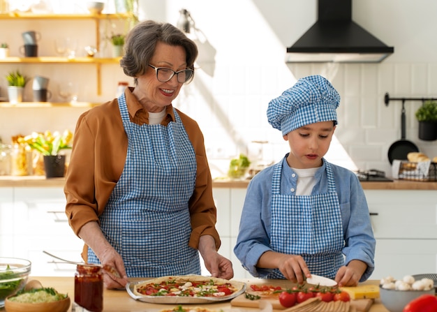 Foto gratuita donna e bambino del colpo medio che cucinano insieme