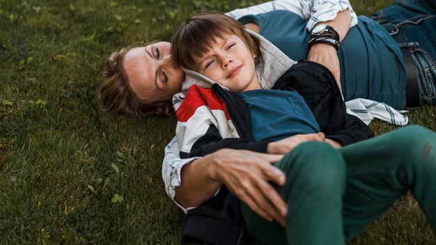 Medium shot woman and kid on grass