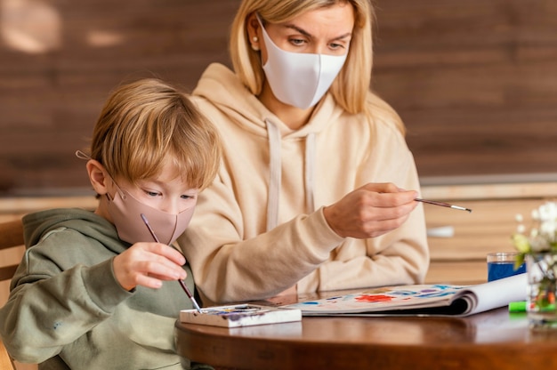 Medium shot woman and kid holding brushes