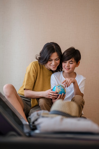 ミディアムショットの女性と地球儀を保持している子供