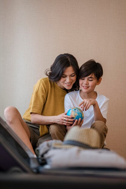 Medium shot woman and kid holding globe