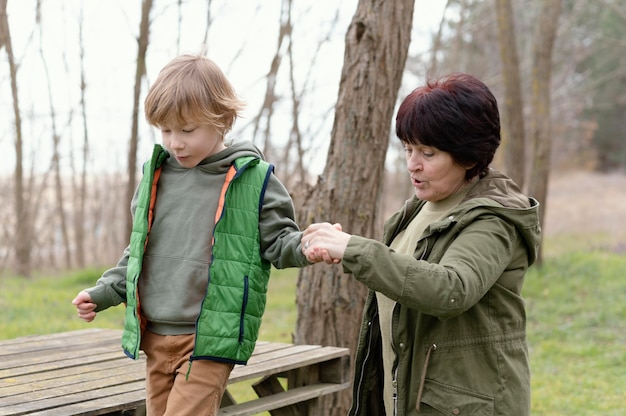 Medium shot woman and kid holding hands
