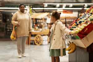 Foto gratuita colpo medio donna e bambino al mercato