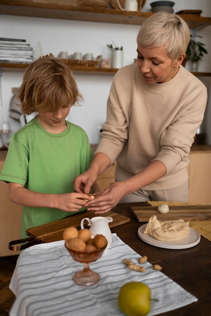 ミディアムショットの女性と子供が食べ物を準備する