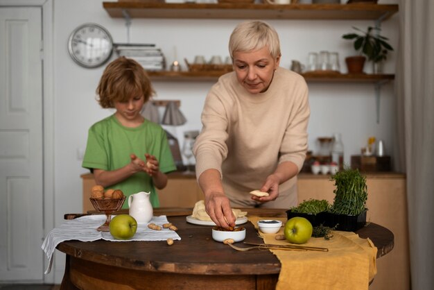 ミディアムショットの女性と子供が食べ物を準備する