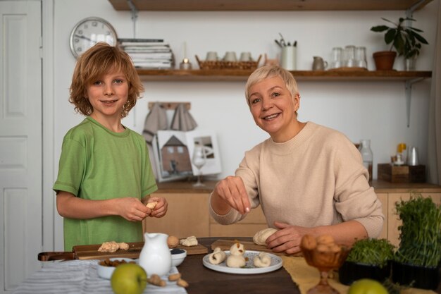 ミディアムショットの女性と子供が食べ物を準備する