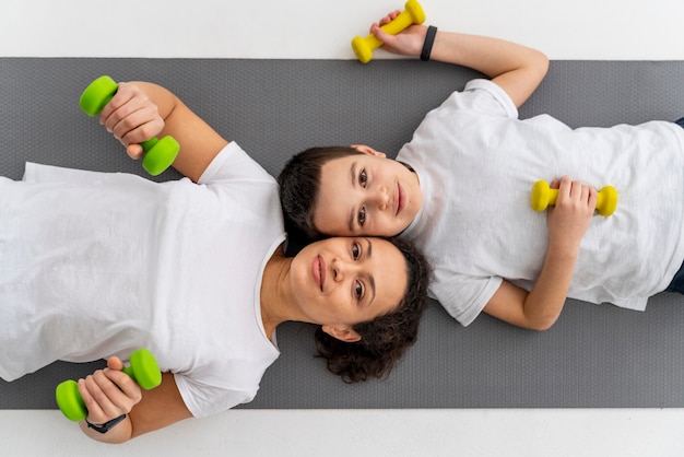 Free photo medium shot woman and kid with dumbbells