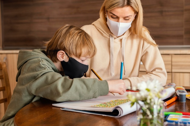 Free photo medium shot woman and kid with mask