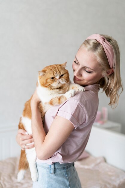 Medium shot woman kissing cat