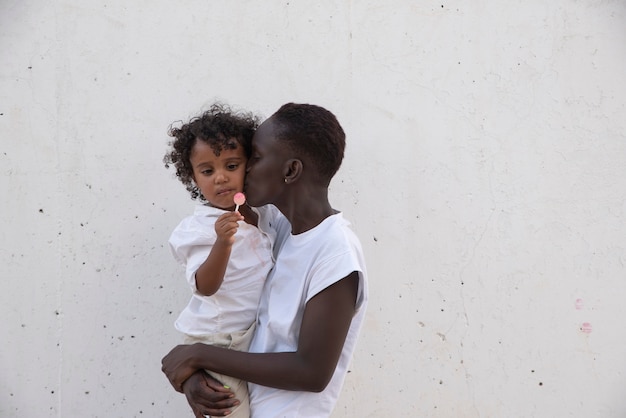 Medium shot woman kissing kid on cheek