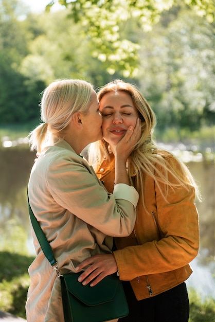 Medium shot woman kissing lover on cheek