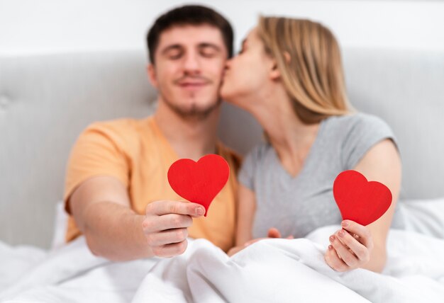 Medium shot woman kissing man on the cheek