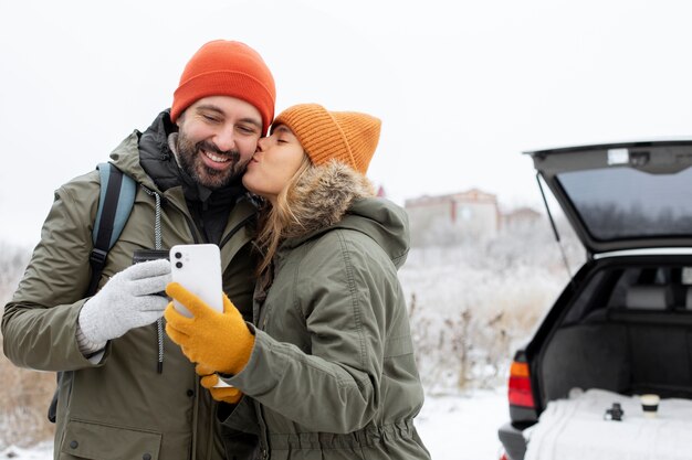 Medium shot woman kissing man on cheek