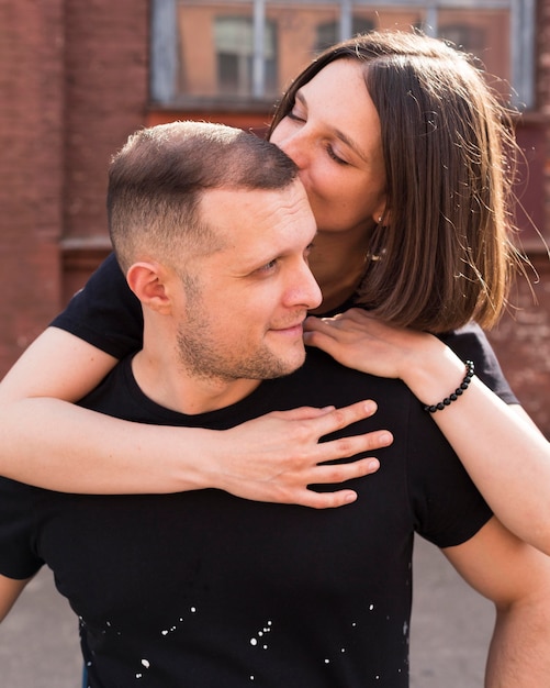 Medium shot woman kissing man on head