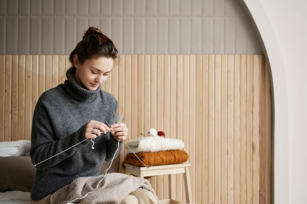 Medium shot woman knitting at home