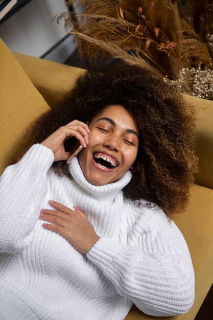 Medium shot woman laughing on couch