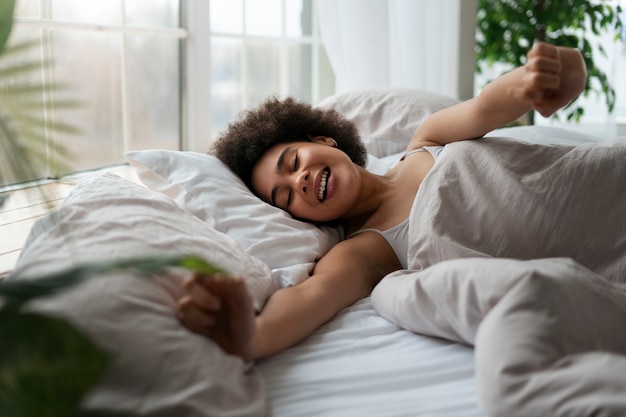 Foto gratuita donna di taglio medio sdraiata a letto