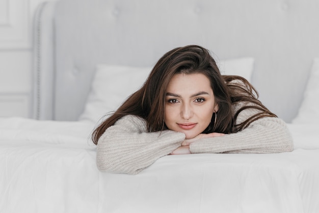 無料写真 ベッドに横たわっているミディアムショットの女性
