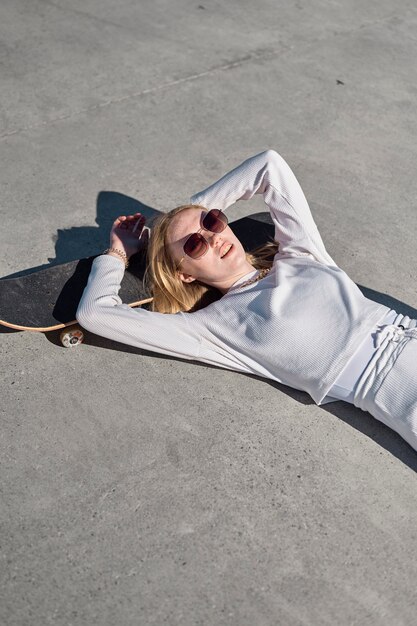 Medium shot woman laying on skateboard