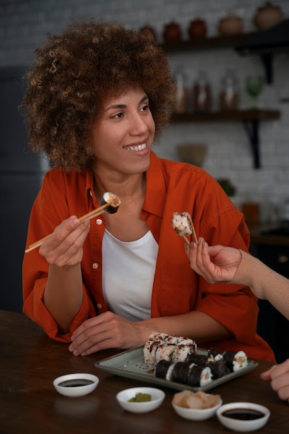 Бесплатное фото Женщина среднего роста учится готовить суши