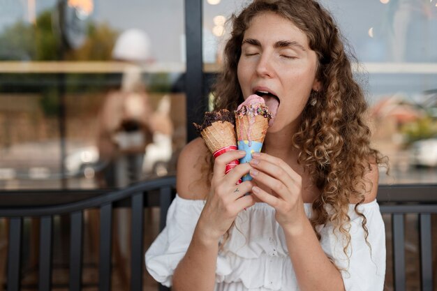 Medium shot woman licking ice cream cone