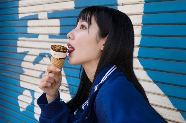 Medium shot woman licking ice cream cone