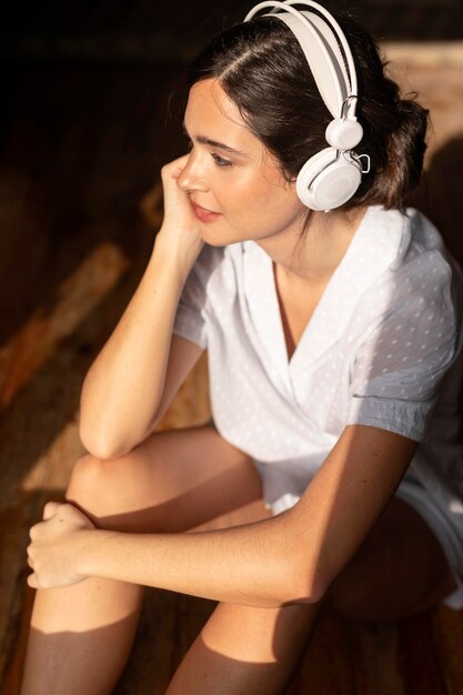 Medium shot woman listening to music