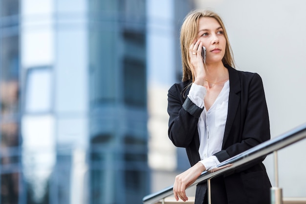 ミディアムショットの女性がbuldingの前で離れています。