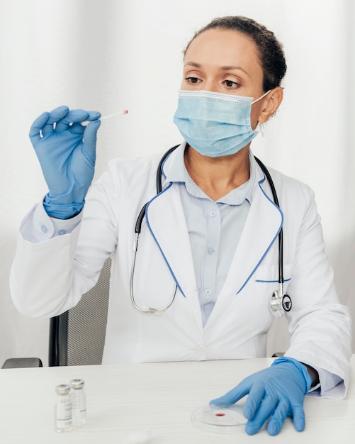 Medium shot woman looking at cotton swab