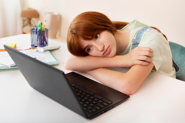 Medium shot woman looking at laptop