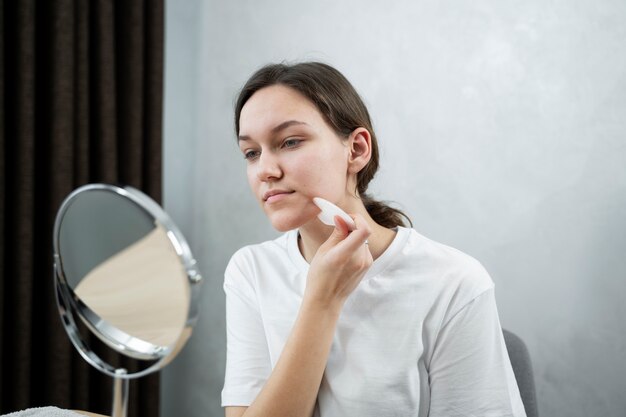 Medium shot woman looking in mirror