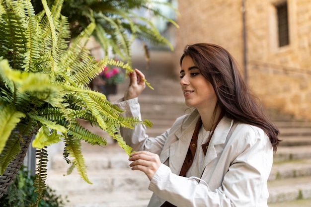 Medium shot woman looking at plant