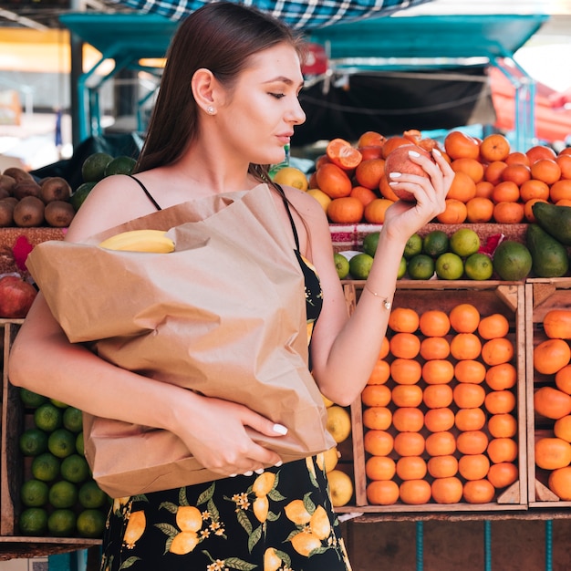 Medium shot woman looking at a pomegranate