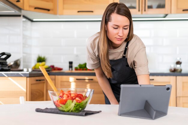 Medium shot woman looking at tablet