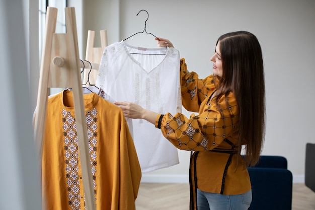 medium shot woman looking at ukranian shirt