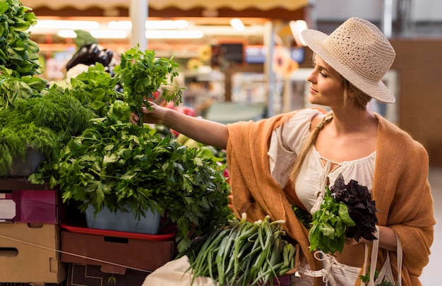 Free photo medium shot woman looking for veggies