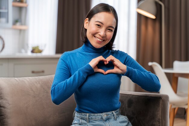 Medium shot woman making heart shape