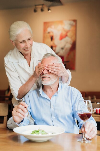 Medium shot woman making husband a surprise 