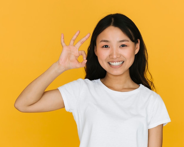 Medium shot woman making the ok sign