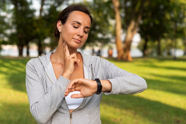 Medium shot woman measuring her pulse