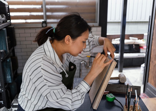 Free photo medium shot woman measuring wood piece