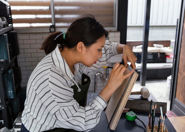 Medium shot woman measuring wood piece